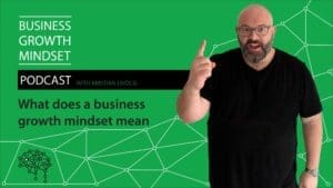 Kristian Livolsi pointing upward on a green background with the text 'What does a business growth mindset mean' for the Business Growth Mindset Podcast.