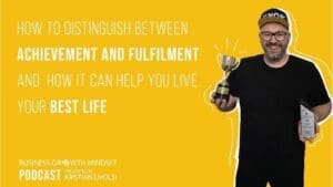 Kristian Livolsi on the Business Growth Mindset Podcast holding a trophy and an award to discuss achievement and fulfillment.