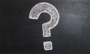 A large white question mark drawn in chalk on a dark blackboard, symbolizing the hidden secrets that will help a business grow and flourish.