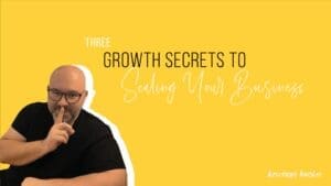 Kristian Livolsi holding a finger to his lips against a yellow background, symbolizing the growth secrets to scaling your business.